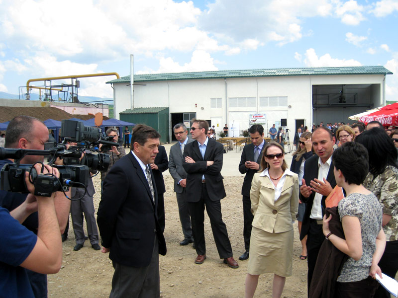 people in business suits standing near large rural building
